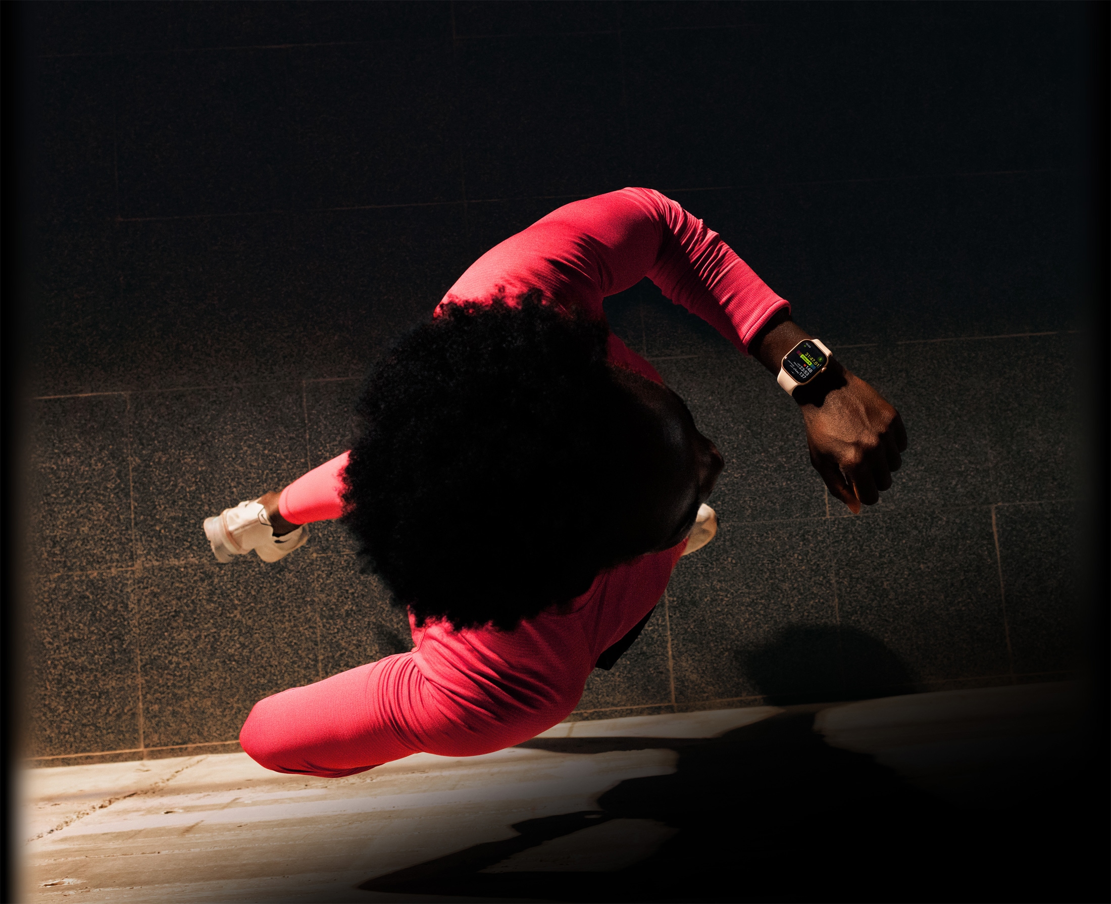 شخص يركض ويتحقق من التقدم في تطبيق التمرين على Apple Watch Series 11‏