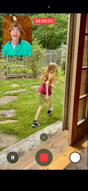 Pantalla de un iPhone 17 que usa la Captura Dual para grabar con la cámara trasera a una niña corriendo y con la cámara frontal a un hombre viéndola