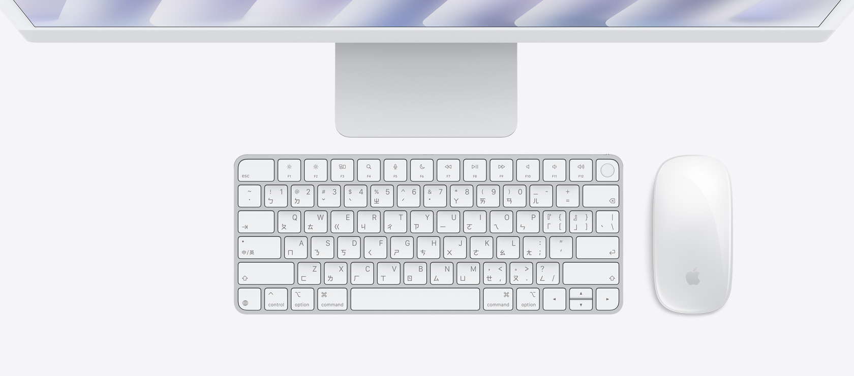 銀色 iMac 俯視圖,展示同色系的滑鼠與鍵盤