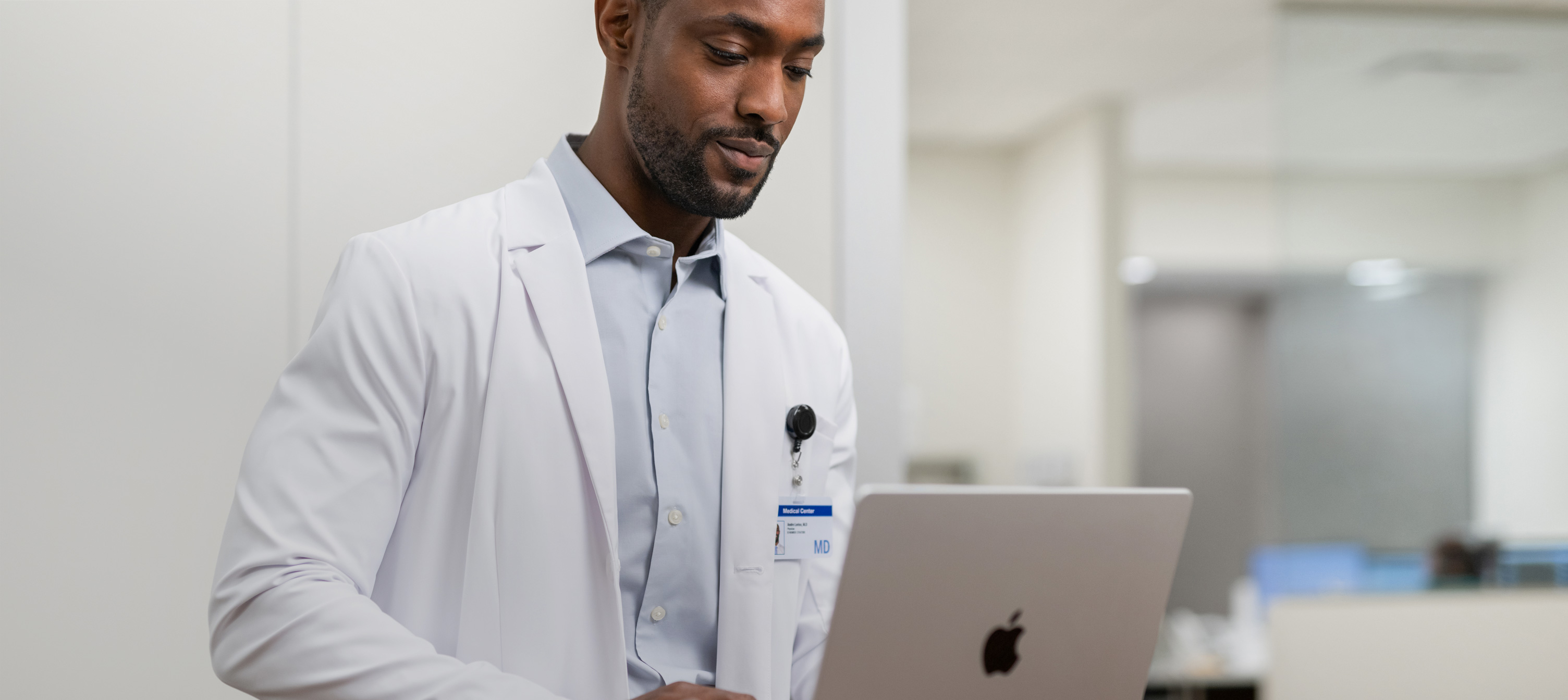 Um médico trabalhando em seu MacBook Pro no hospital.