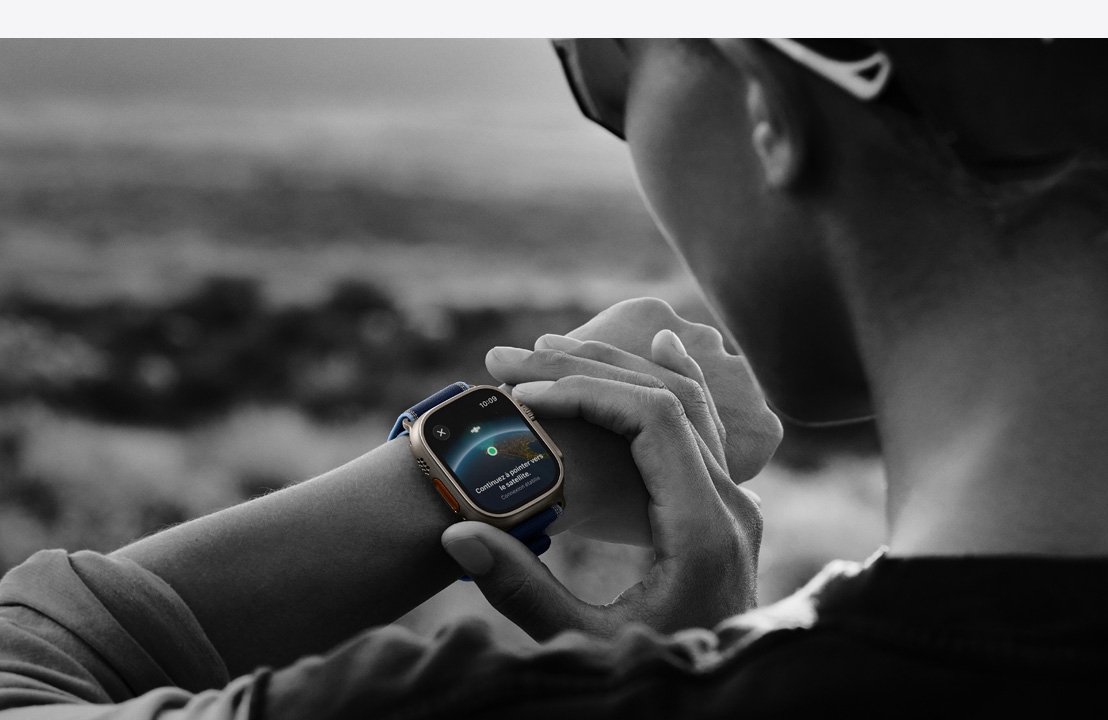 Une personne utilisant la communication satellite bidirectionnelle sur Apple Watch Ultra 3 en randonnée
