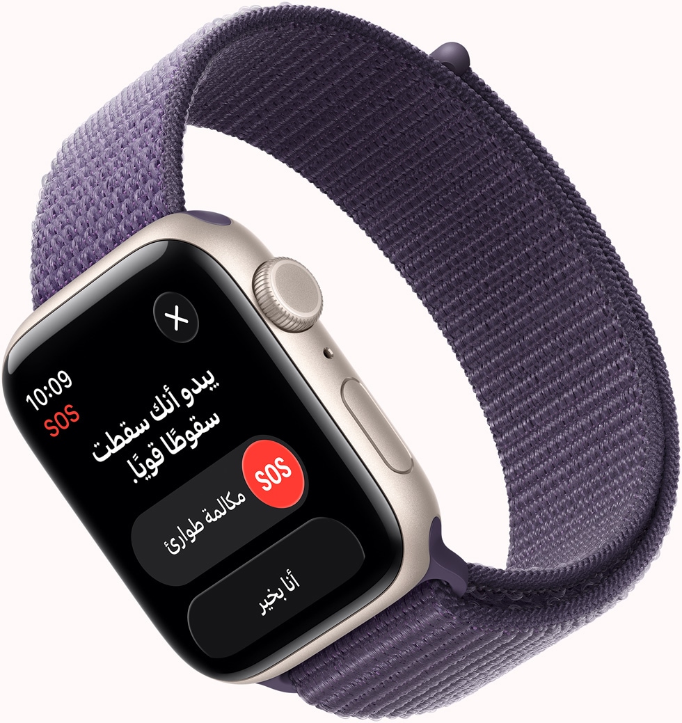 Apple Watch SE 3 بإطار من الألومنيوم ولون ضوء النجوم، وإشعار SOS لميزة اكتشاف السقوط، وزر مكالمة طوارئ وزر أنا بخير، والجزء الخارجي الأيمن يُظهر التاج الرقمي والميكروفون والزر الجانبي، وحزام Loop رياضي بلون ليلكي ضبابي