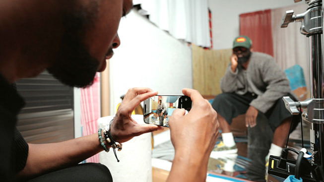 A behind-the-scenes shot of Karston Tannis capturing a portrait of designer Ade Okuboyejo. Shot on iPhone 16 Pro Max.