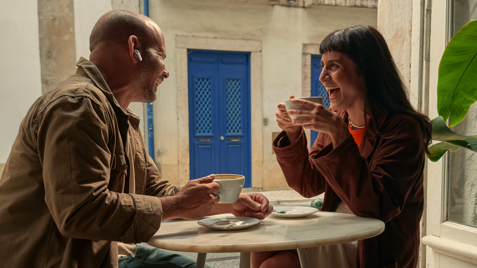 An image of a user wearing AirPods Pro 3 while having a conversation in a loud restaurant environment.