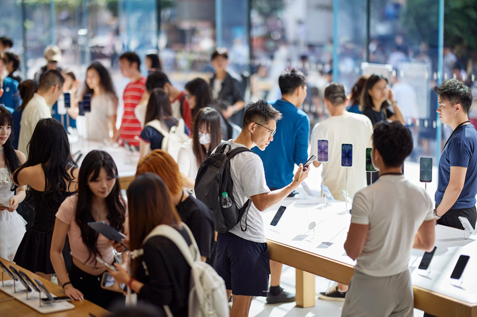 Customers explore the latest iPhone line-up at Apple Nanjing East in Shanghai.