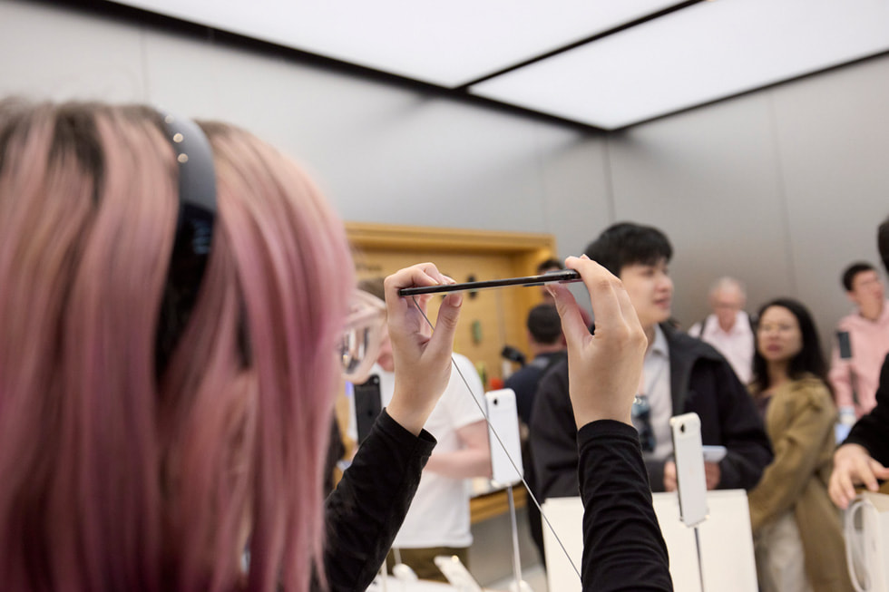 A customer holds up iPhone Air to take a closer look at its thinness at the Apple Sydney store in Australia.