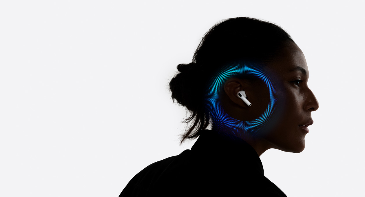 Una persona usando unos AirPods 3, con ondas sonoras rodeando su oreja