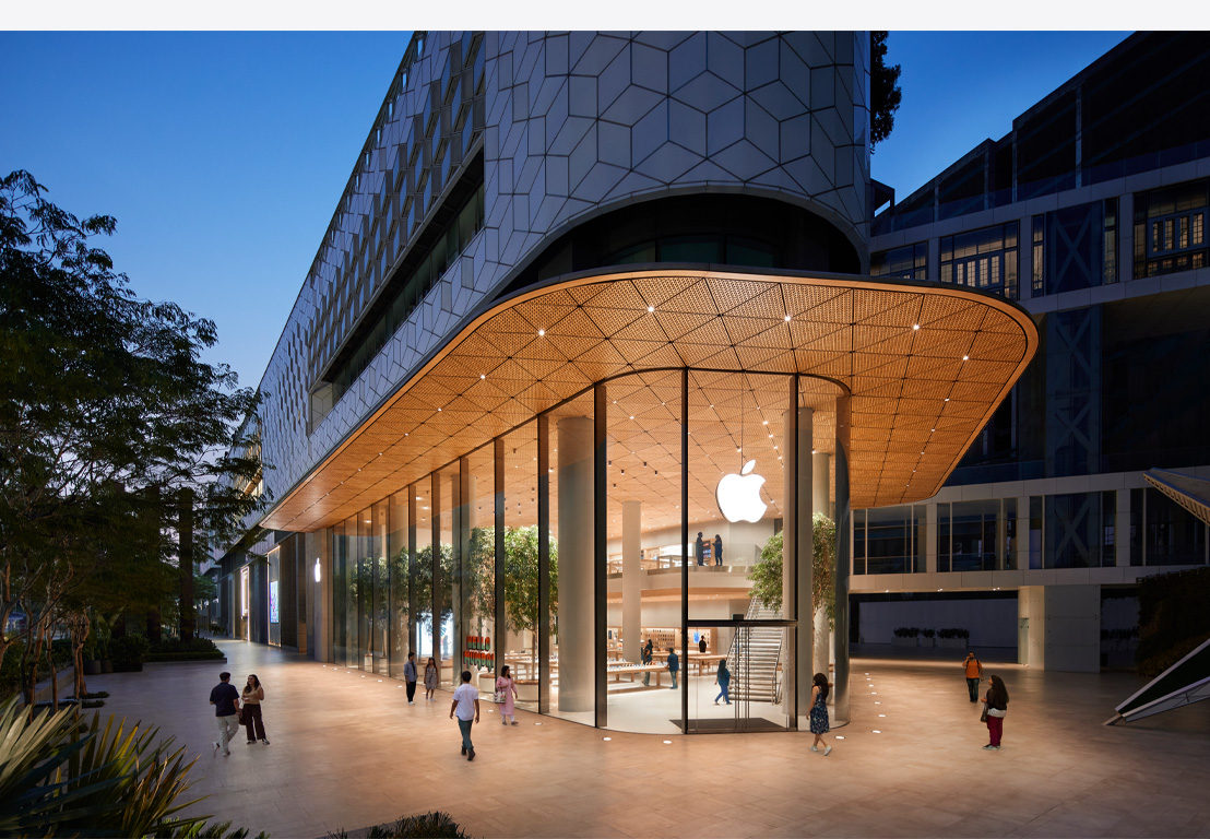 晚上的 Apple Store,展示多塊玻璃窗,室內明亮,正門頂部有 Apple 標誌。